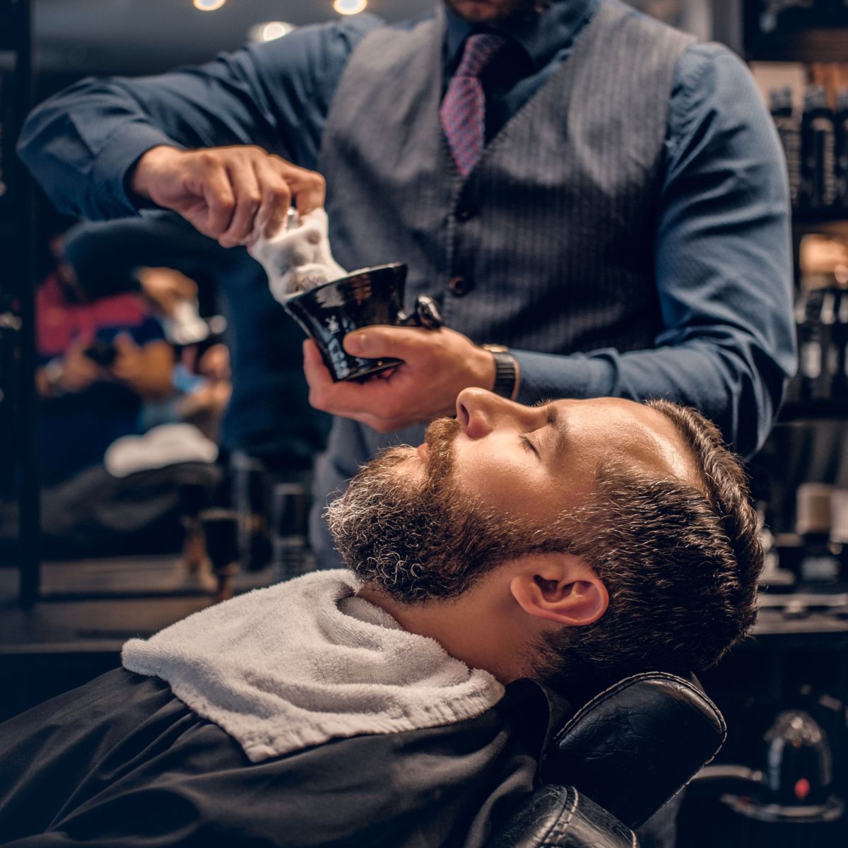Relaxing man gets a shave from a barber who knows his style.